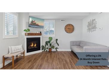 Bright living room features a cozy fireplace, stylish decor, and comfortable seating area at 760 W Asbury Ave, Denver, CO 80223