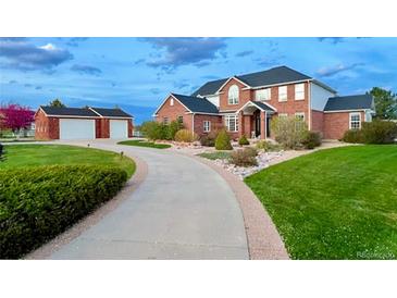 Brick two-story house with attached garage and landscaped yard at 221 Mulligan Lake Dr, Mead, CO 80542