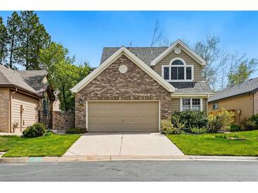 Charming two-story home features a brick facade and a two-car garage with a well-manicured lawn at 2252 S Yosemite Cir, Denver, CO 80231
