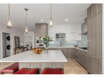 Modern kitchen with stainless steel appliances, a large island, and stylish pendant lighting creates a bright and welcoming space at 1401 Delgany St # 204, Denver, CO 80202