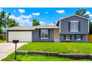 Charming gray home featuring a well-maintained lawn and complemented by a mailbox and garage door at 16322 E Idaho Pl, Aurora, CO 80017