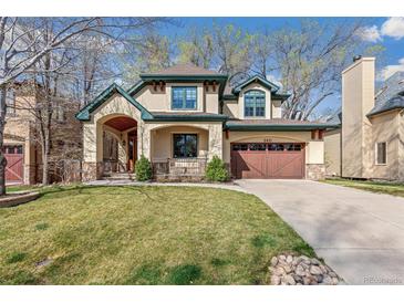Traditional two-story home with a well-kept lawn, lush trees, and a wide driveway for easy parking at 2411 S Garfield St, Denver, CO 80210