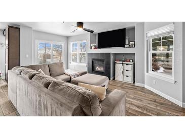 Cozy living room features a fireplace, large windows, and a comfortable sectional sofa at 23500 E Alamo Pl # B19, Aurora, CO 80016