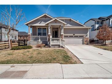 Charming home with well-manicured lawn, covered porch, and attached two-car garage at 4834 S Wenatchee St, Aurora, CO 80015