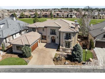 Stunning two-story home with a tile roof, well-manicured landscaping, and an attached two-car garage at 9099 E Harvard Ave, Denver, CO 80231