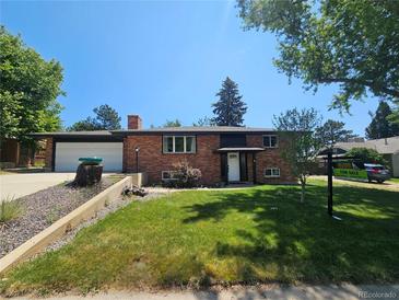 Charming brick home with a well-maintained lawn and mature trees in a quiet neighborhood at 6614 Everett St, Arvada, CO 80004