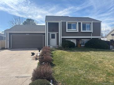 Charming two-story home with a well-maintained front yard and an attached two-car garage at 5971 S Tabor St, Littleton, CO 80127