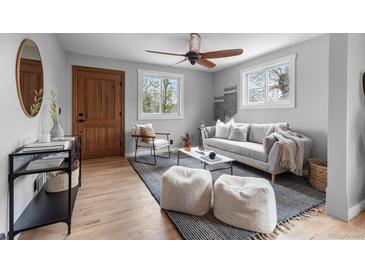 Bright living room features hardwood floors, a ceiling fan, and modern decor at 610 E Baseline Rd, Lafayette, CO 80026