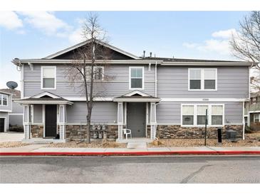 Inviting exterior of a gray two-story home with stone accents and well-maintained landscaping at 17200 Waterhouse Cir # D, Parker, CO 80134