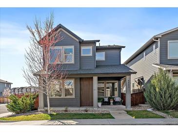 Two story house showcasing a well manicured front yard and charming porch at 6805 Canosa St, Denver, CO 80221