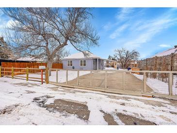 Cute bungalow with a fenced front yard and snowy landscape at 15235 W 43Rd Ave, Golden, CO 80403