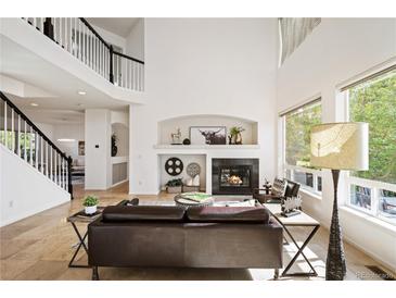 Bright living room boasts a fireplace, high ceilings, large windows, and an open floor plan at 4340 Nelson Dr, Broomfield, CO 80023