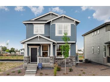 Charming two-story home features a stylish gray exterior, covered porch, and well-maintained landscaping at 485 Bennett Ave, Bennett, CO 80102