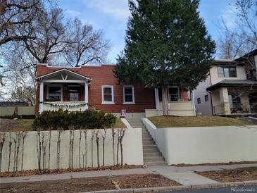 Charming red brick home with a welcoming front porch and landscaped front yard at 624 S Ogden St, Denver, CO 80209