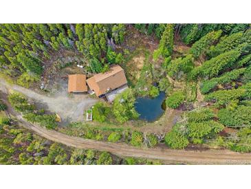 Aerial view of a charming mountain home with a pond and surrounded by lush green trees at 80 Castlewood Ct, Evergreen, CO 80439