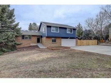 Charming two-story home with a brick and blue exterior and a spacious driveway at 6389 S Ponds Way, Littleton, CO 80123