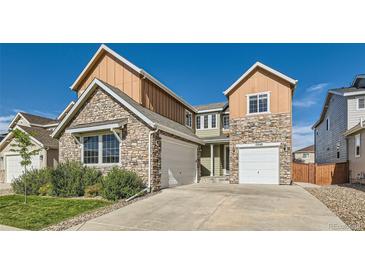 Two-story home featuring stone and wood-style siding, a well-kept lawn, and a two-car garage at 17040 Galapago Ct, Broomfield, CO 80023