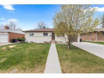 Charming single-story home with a well-manicured lawn and a concrete walkway leading to the front door at 3055 S Winona Ct, Denver, CO 80236