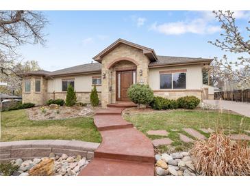 Charming home with a brick-arched entry, manicured landscaping, and a winding walkway at 6071 S Detroit St, Centennial, CO 80121