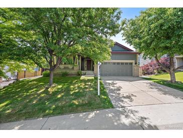 Charming home with a two-car garage, mature trees, and a well-maintained lawn at 5932 S Versailles St, Aurora, CO 80015