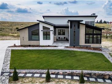 Stunning modern home featuring manicured lawn, stone accents and a unique architectural design at 8765 Canyon Wind St, Parker, CO 80138
