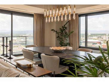 Bright dining room featuring a modern chandelier, large windows with city views, and stylish decor at 1133 14Th St # 2000, Denver, CO 80202