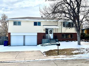 Charming two-story home featuring a two-car garage, brick accents, and a classic front entrance at 7460 W Bails Ave, Lakewood, CO 80232