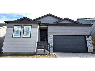 New construction shows a Craftsman style home in gray with stone accents and a two car garage at 17136 W 92Nd Loop, Arvada, CO 80007