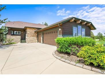 Charming single-Gathering home showcasing a stone and brown exterior, complemented by a spacious driveway and lush landscaping at 23961 E Easter Pl, Aurora, CO 80016