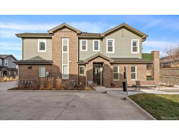 Two-story townhome with brick and siding exterior, a bench, and a small yard at 5199 S Fairplay St, Aurora, CO 80015