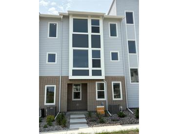 Charming townhome featuring a modern exterior design with large windows and landscaped front yard at 14223 Currant St, Broomfield, CO 80020