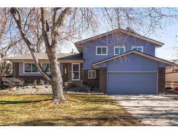 Charming two-story home featuring a blue exterior, attached garage and mature landscaping at 1501 S Youngfield Ct, Lakewood, CO 80228