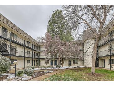 Charming apartment complex courtyard featuring landscaped grounds and mature trees with walkways at 5875 E Iliff Ave # 115, Denver, CO 80222