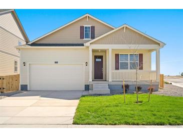 Inviting single-Gathering home boasts a two-car garage, covered porch, and manicured lawn at 817 Ledge St, Lochbuie, CO 80603