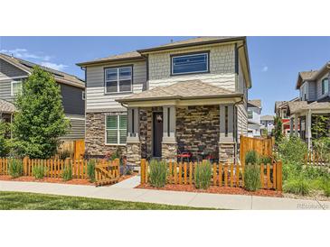Charming two-story home featuring a stone facade, covered porch, and a fenced front yard at 764 N Quatar St, Aurora, CO 80018