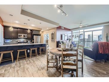 Open-concept living space featuring kitchen with breakfast bar, dining area and a large living room with city views at 2001 Lincoln St # 2213, Denver, CO 80202