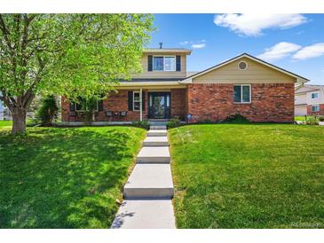 Charming two-story brick home with mature landscaping and a welcoming walkway at 6918 E Long Ave, Centennial, CO 80112
