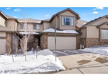 Two-story townhome with attached garage and snow-covered landscaping at 7662 Bristolwood Dr, Castle Pines, CO 80108