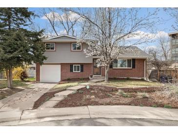 Charming two-story home with brick and siding, a well-manicured lawn, and a blossoming tree in the front yard at 537 S Grape St, Denver, CO 80246