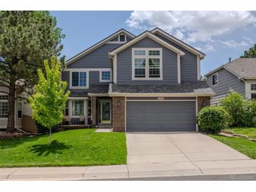 Charming two-story home features a well-manicured lawn, gray siding and a spacious two car garage at 17018 Carr Ave, Parker, CO 80134