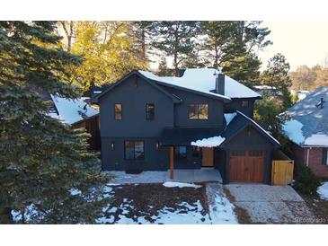 Stunning exterior view of a two-story home with a well-maintained yard and classic architectural features at 715 Glencoe St, Denver, CO 80220