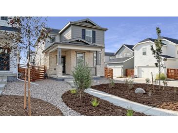 Charming two-story home featuring a stone facade, covered porch, and xeriscaped front yard at 3365 N Coolidge Way, Aurora, CO 80019