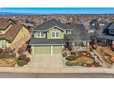 Stunning two-story home featuring a covered front porch, a two car garage, and lush landscaping in a desirable neighborhood at 10726 Amesbury Way, Highlands Ranch, CO 80126