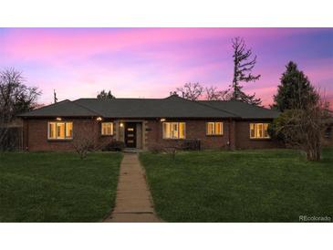 Charming brick home with a well-maintained lawn and walkway leading to the front door at 2835 N Monaco Pkwy, Denver, CO 80207