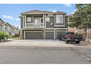 Modern townhome showing multiple garage doors and a pickup truck parked in the driveway at 1409 Carlyle Park Cir, Highlands Ranch, CO 80129