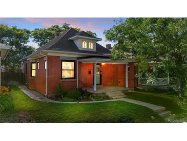 Charming brick home with a covered front porch and well-manicured lawn at 1031 S Pennsylvania St, Denver, CO 80209
