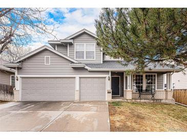 Charming two-story home with a well-manicured lawn, attached two-car garage, and welcoming front porch at 13421 Humboldt Way, Thornton, CO 80241