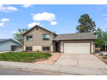 Inviting two-story home with attached garage, manicured lawn, and charming brick accents at 5338 Granby St, Denver, CO 80239