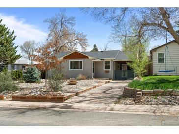 Charming single-story home featuring a cozy front porch and landscaped yard with rock features and lovely mature trees at 3368 S Corona St, Englewood, CO 80113