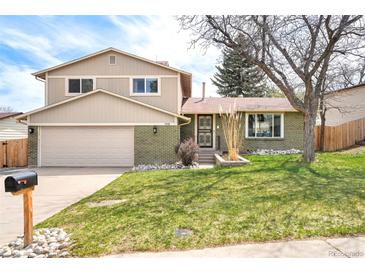 Charming two-story home boasts a manicured front lawn and a combination brick and siding exterior at 3408 S Kittredge St, Aurora, CO 80013